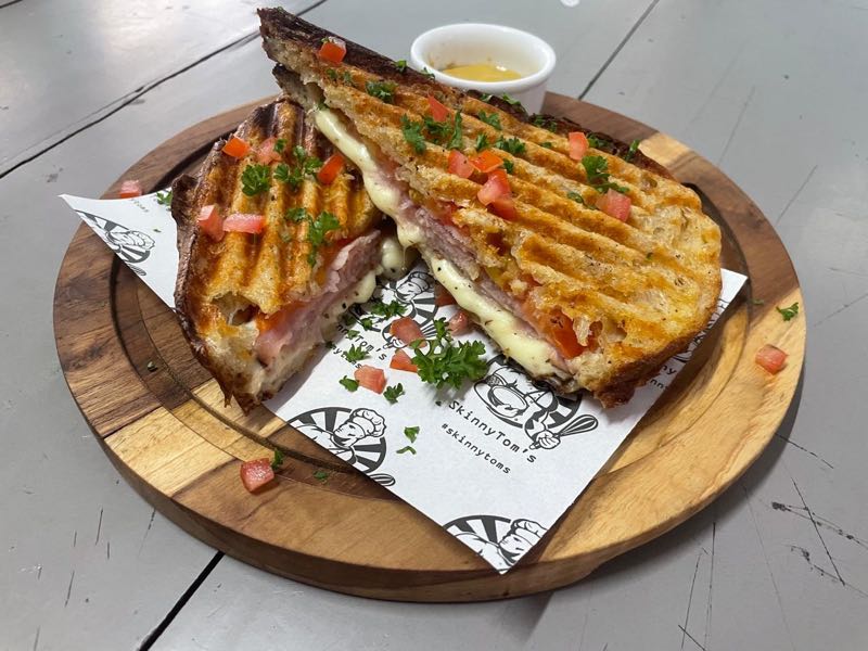 Toasted artisan sourdough melt with melted cheddar, grilled ham, and tomatoes